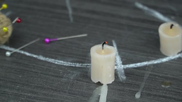 A burning candle on a magic circle next to occult needles. conducting a seance, a mystical ritual. — Stock Video