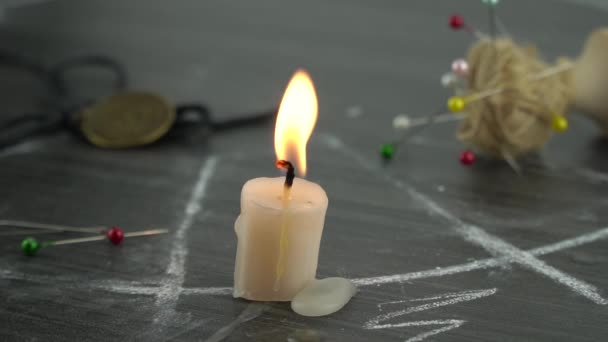 A burning candle on a magic circle next to occult needles. conducting a seance, a mystical ritual. — Stock Video