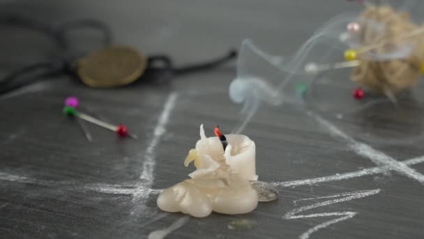 Ένα αναμμένο κερί σε ένα μαγικό κύκλο δίπλα σε απόκρυφες βελόνες. Διεξάγοντας μια πνευματιστική τελετή.. — Αρχείο Βίντεο