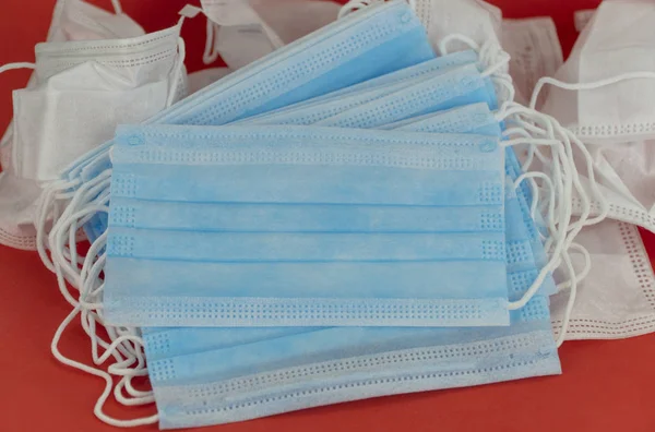 Cerrahi koruyucu maske. Yüzünde tıbbi solunum bandajı var. Koronavirüs karantinası kavramı. Wuhan salgını. Tehlikeli Çin romanı virüsü 2019-ncov.copy space. Kırmızı arkaplan