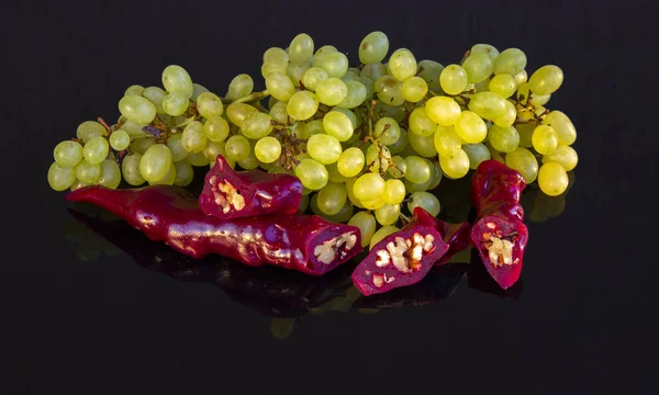 Вкусные восточные сладости церковкела и гроздь винограда на темной стеклянной поверхности — стоковое фото