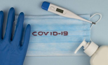 Küresel salgın COVID 19 'u durdurun. Coronavirus önleme cerrahi maskeler ve el hijyeni için dezenfektan jel yayma koruması. Vücut ısısını ölçmek için elektronik termometre. en üstteki görünüm.