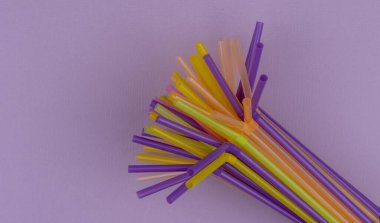 Mor arkaplanlı ve fotokopi alanı olan yaz kokteylleri için renkli pipetler. Üst Manzara. Kamış Günü, 3 Ocak