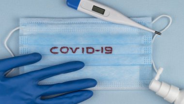 Küresel salgın COVID 19 'u durdurun. Coronavirus önleme cerrahi maskeler ve el hijyeni için dezenfektan jel yayma koruması. Vücut ısısını ölçmek için elektronik termometre. en üstteki görünüm.
