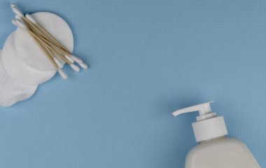 Dezenfektan jeli ve mavi arka planda doğal pamuk çubukları. COVID-19 'un küresel salgınını durdurun. 