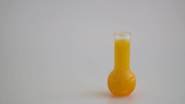 Szkło Laboratoryjne Płynem Białym Tle Kolba Chemiczna Szklana Żółtym Odczynnikiem — Wideo stockowe