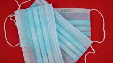 Koronavirüse karşı korunmak için antiviral tıbbi maske. Cerrahi koruyucu maske. Kırmızı arka planda tıbbi solunum bandajı var. Virüs ve salgın COVID-19 'un yayılmasının önlenmesi.
