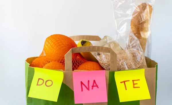 food donations in a paper bag on a white background. product delivery concept.