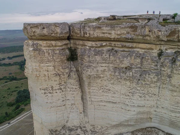 Beyaz kaya. Kırım. İnsanlar uçurumun kenarında duruyor. İnsansız hava aracından genel görünüm.