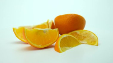 Beyaz arka planda turuncu dilimler dönüyor. Biraz bulanık. 360 döndürme.