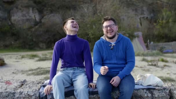 Два гея сидят в море — стоковое видео