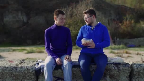 Two gay sit at sea — Stock Video