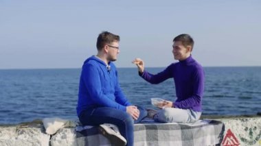İki gay denizde oturuyor.