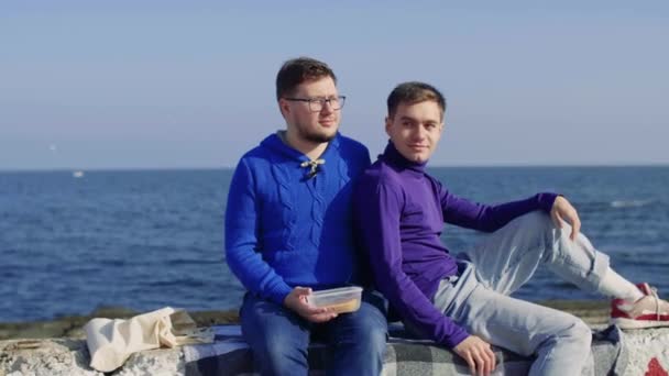 Dos gay sentarse en el mar — Vídeos de Stock