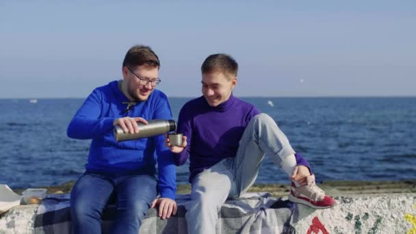 Dos gay sentarse en el mar — Vídeo de stock