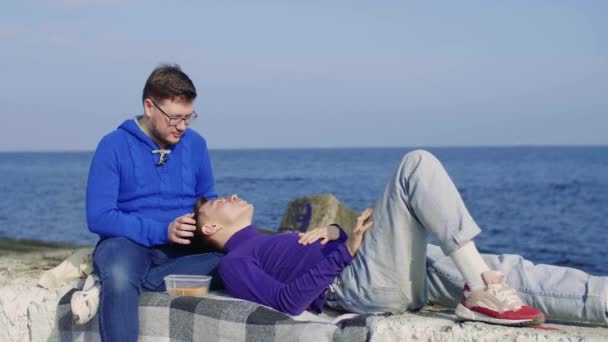 Два гея сидят в море — стоковое видео