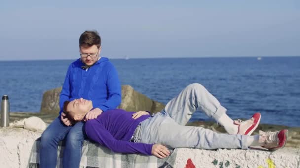Two gay sit at sea — Stock Video