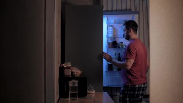 Isst nachts aus dem Kühlschrank — Stockvideo