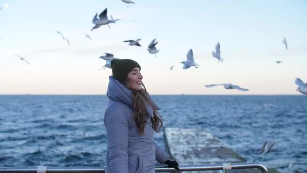 Mädchen in warmer Jacke, umgeben von Möwen — Stockvideo