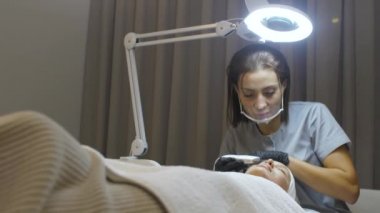 Ofisteki bir güzellik uzmanı prosedürleri gerçekleştirir.