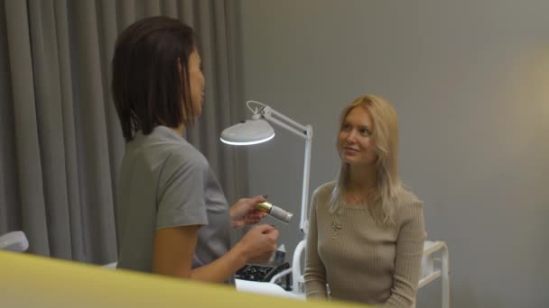 Косметолог в офисе проводит процедуры — стоковое видео