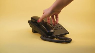 Sarı arkaplandaki düğmeli telefona bas