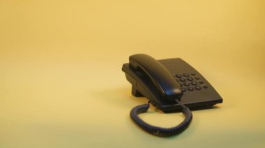 Sarı arkaplandaki düğmeli telefona bas