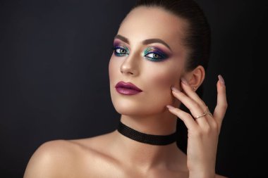 Kız model, koyu arkaplanda makyajlı bir portre..
