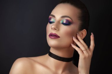 Kız model, koyu arkaplanda makyajlı bir portre..