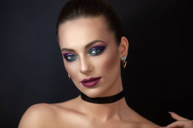 Kız model, koyu arkaplanda makyajlı bir portre..