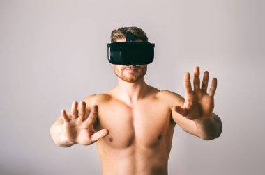 VR kulaklık giyen bir stüdyoda üstsüz genç adam