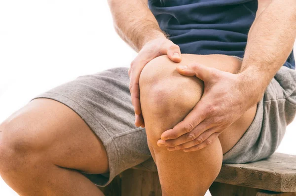 Muž s bolestí kolena nad bílým pozadím — Stock fotografie