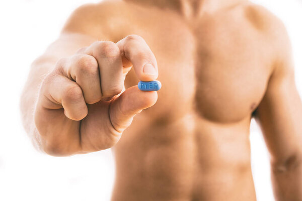 Man holding a pill used for Pre-Exposure Prophylaxis (PrEP) 