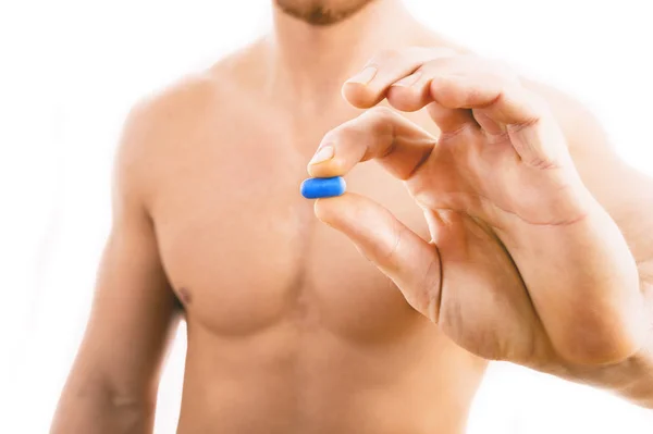 Musclé jeune homme tenant pilule bleue — Photo
