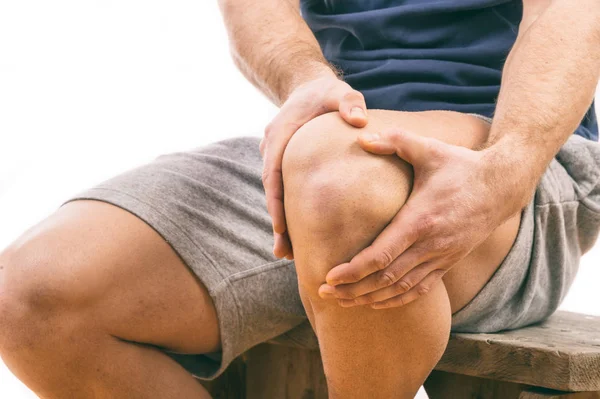 Hombre con dolor de rodilla sobre fondo blanco Imágenes de stock libres de derechos