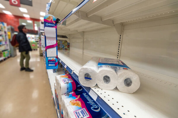 Montreal, CA - 20 March 2020: Empty shelves of toilet paper in a supermarket. Shortage of supplies due to panic of Coronavirus.