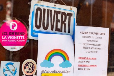 Montreal, CA - 13 Mayıs 2020: Ca va bien aller (Her şey yoluna girecek) mesajı ve Covid 19 pandemisi sırasında bir mağazanın kapısında Ouvert / Open tabelası