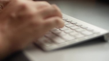 Asyalı bir erkek, klavyeye yazı yazıyor..