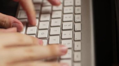 Asyalı bir erkek, klavyeye yazı yazıyor..