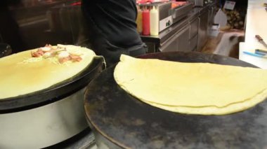 Kadın elektrikli ocakta krep yapıyor. Sokakta lezzetli yemekler hazırlıyorum..