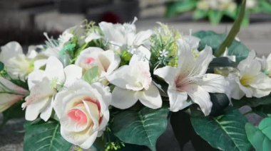 Gündüz vakti mezar taşları ve çiçeklerle dolu bir mezar.