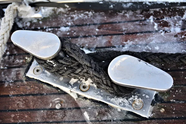 Yatta beyaz, kalın bir halatı olan bir krampon kıç şahini ya da yay satıcısı olarak kullanılabilir. Etrafında biraz kar var.