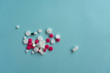 Mavi arka planda çeşitli şekillerde beyaz ve kırmızı haplar var. Coronavirus, tedavi, haplar, ilaç, salgın, virüs, hastalık. Mesaj için. Üst görünüm, alanı kopyala.