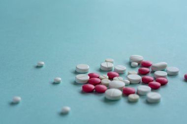 Mavi arka planda çeşitli şekillerde beyaz ve kırmızı haplar var. Coronavirus, tedavi, haplar, ilaç, salgın, virüs, hastalık. Mesaj için. Üst görünüm, alanı kopyala.