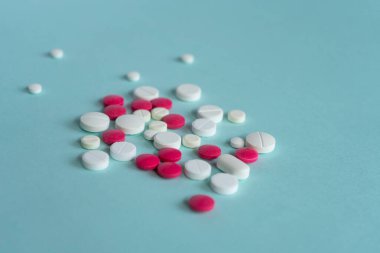 Mavi arka planda çeşitli şekillerde beyaz ve kırmızı haplar var. Coronavirus, tedavi, haplar, ilaç, salgın, virüs, hastalık. Mesaj için. Üst görünüm, alanı kopyala.