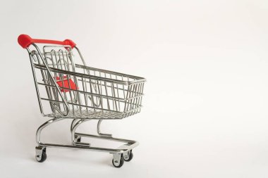 Boş bir arka plan üzerinde kırmızı plastik saplı çelikten tüketici yiyecek vagonu