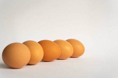 Beş taze kahverengi tavuk yumurtası arka planda çapraz olarak. Paskalya tatili, kopyalama alanı