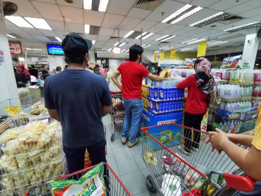 KUALA TERENGANU, MALAYSIA - 16 Mart 2020: Malezyalılar, Malezya hükümetinden sınırlı hareket emrinin (RMO) Covid-19 'un yayılmasını engellemesini bekleyerek, yerel Sabasun mağazasından bakkal alışverişi yapıyorlar.