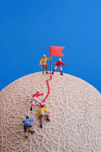 Miniature Toys Group Mountain Climbers Reaching Top Rock Melon Fruit — Stock Photo, Image