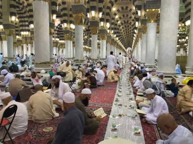 ALI MADINAH, SAUDI ARABIA-CIRCA Mayıs 2019: Müslüman erkekler Medine 'deki Nabawi Camii' nde günbatımında oruç tutmaya hazırlanıyorlar. Covid-19 yüzünden Medine ve Mekke 'ye Müslümanların girmesine izin verilmedi..